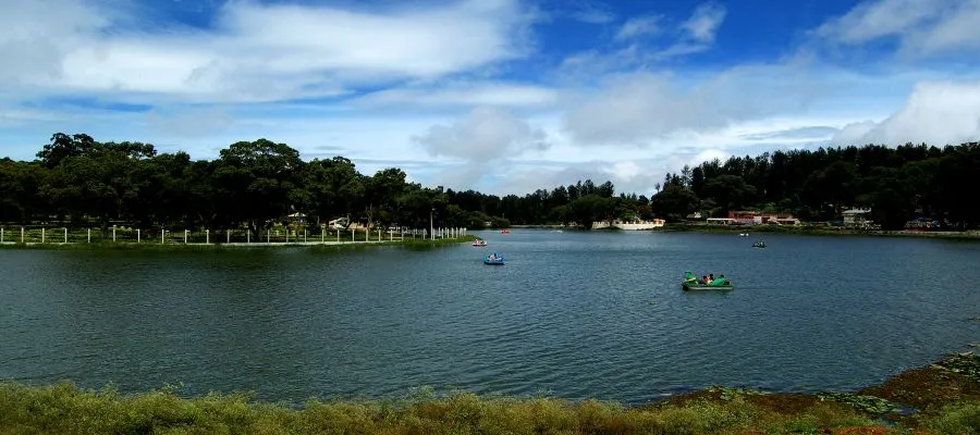 A scenic view of tourists enjoying a boating ride at Yercaud lake.