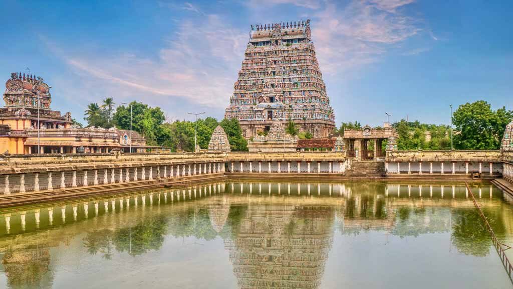 A large water pool reflecting the majestic tower of Nataraja Temple in Chidambaram in the state of Tamil Nadu.