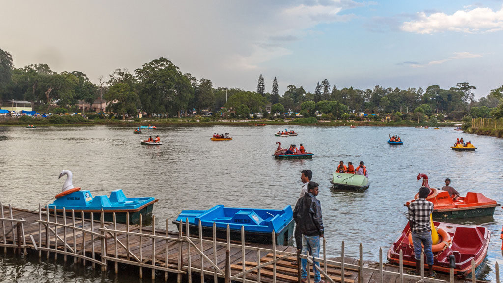 A scenic view of tourists enjoying a boating ride at Yercaud lake.