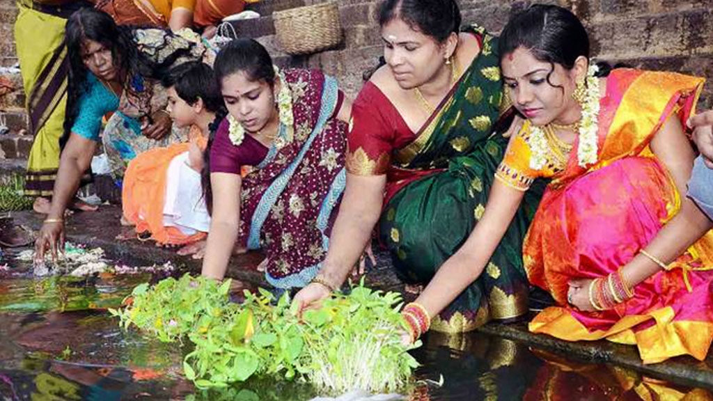 A glimpse of Women dissolving the pot full of plants in a river on the occasion of Aadi perukku.