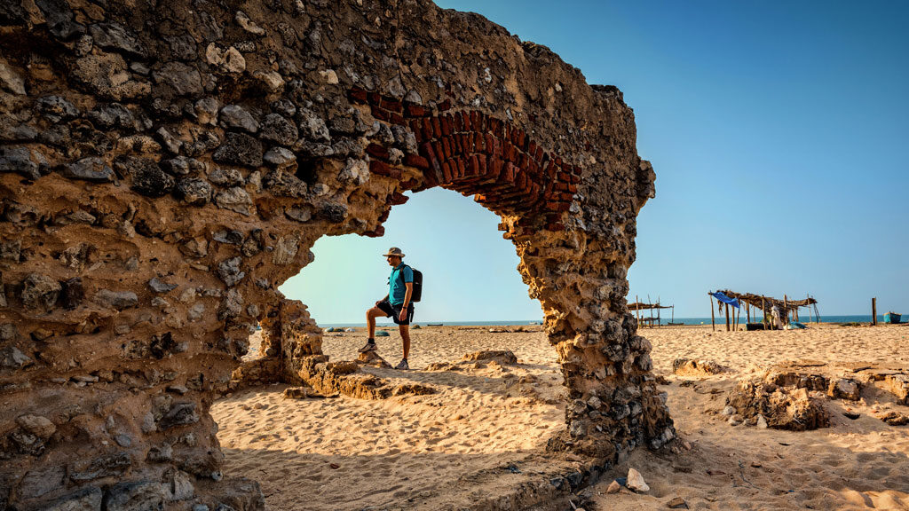 A traveller standing near the destroyed Building in the Ghost Town of Dhanushkodi, in the state of Tamil Nadu, India.